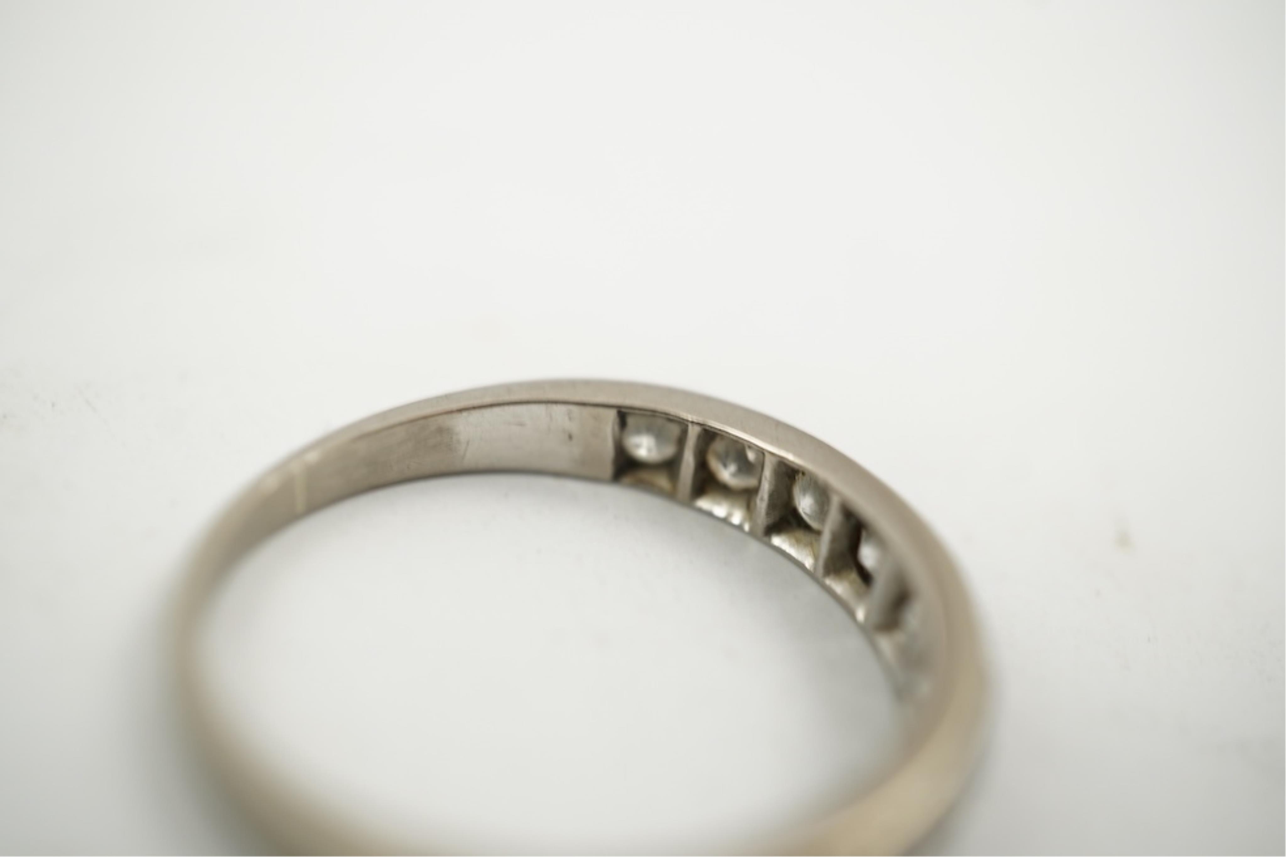 An 18ct white metal and graduated eleven stone diamond set half eternity ring, size P/Q. gross weight 3 grams.